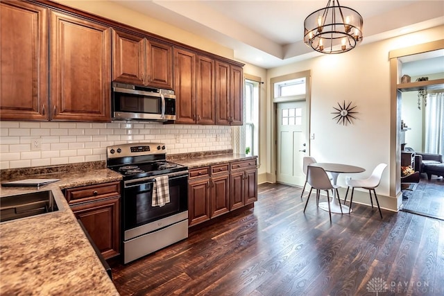 320 N Mechanic St, Lebanon, OH 45036 - kitchen with appliances with stainless steel finishes, a chandelier, decorative backsplash, dark wood finished floors, and hanging light fixtures