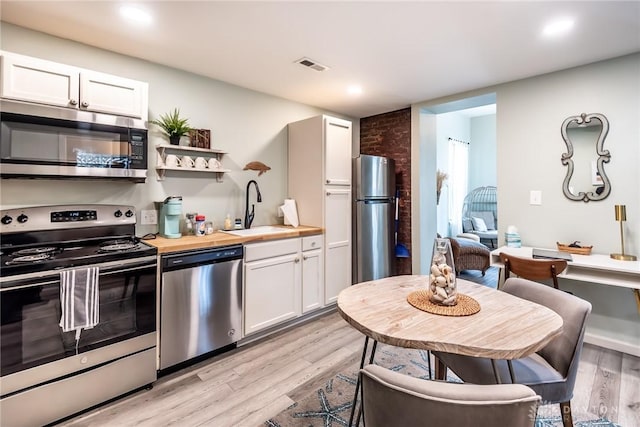 320 N Mechanic St, Lebanon, OH 45036 - kitchen featuring appliances with stainless steel finishes, a sink, light wood-type flooring, white cabinetry, and recessed lighting