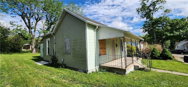 view of property exterior featuring a lawn and covered porch