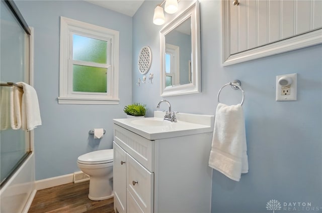 56 W Xenia St, Jamestown Vlg, OH 45335 - full bathroom featuring toilet, vanity, wood finished floors, baseboards, and bath / shower combo with glass door