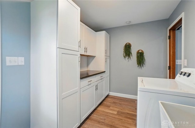 56 W Xenia St, Jamestown Vlg, OH 45335 - laundry room featuring cabinet space, light wood finished floors, washing machine and clothes dryer, and baseboards
