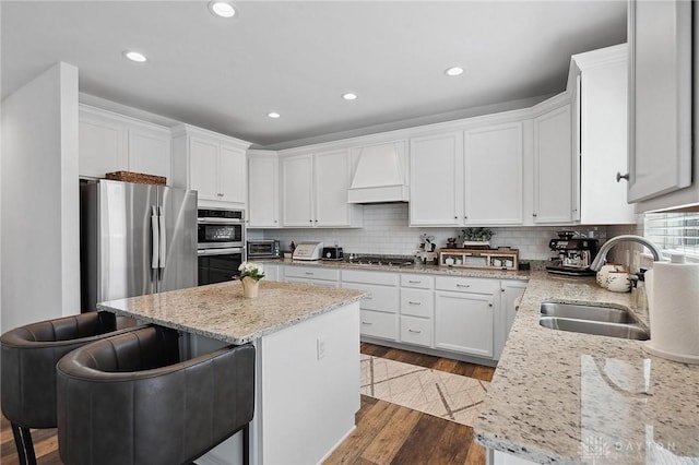 4061 Woodland Ridge Ct, Bellbrook, OH 45440 - kitchen with a sink, premium range hood, stainless steel appliances, a center island, and white cabinets