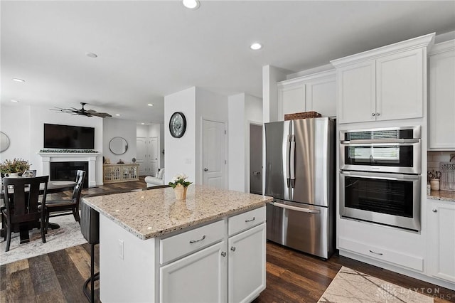 4061 Woodland Ridge Ct, Bellbrook, OH 45440 - kitchen featuring stainless steel appliances, a ceiling fan, a center island, dark wood-style floors, and white cabinetry