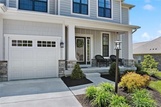 4061 Woodland Ridge Ct, Bellbrook, OH 45440 - view of exterior entry featuring covered porch, stone siding, driveway, board and batten siding, and a garage