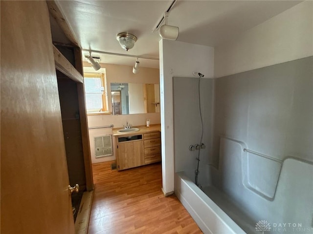 318 E Main St, Bradford, OH 45308 - bathroom featuring track lighting, wood finished floors, shower / washtub combination, vanity, and heating unit
