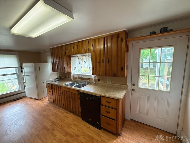 318 E Main St, Bradford, OH 45308 - kitchen with a sink, black dishwasher, brown cabinets, light countertops, and light wood-style flooring
