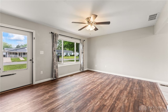 unfurnished room with wood finished floors, a ceiling fan, and baseboards