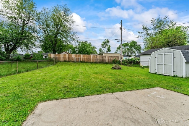view of yard featuring a storage shed, an outdoor structure, and an outdoor fire pit