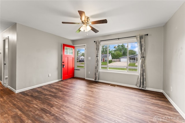 empty room featuring wood finished floors, ceiling fan, and baseboards