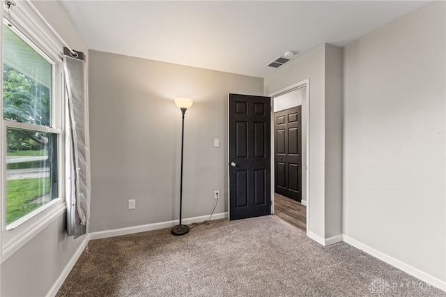 spare room featuring carpet flooring, healthy amount of natural light, and baseboards