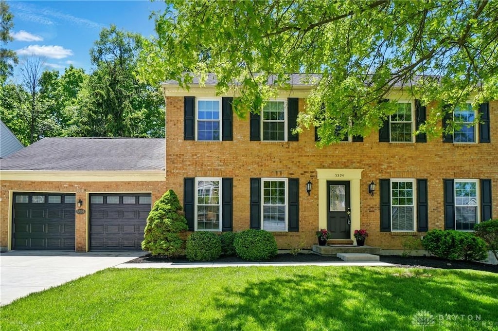 5594 Fawnwood Ln, Colerain Township, OH 45247 - colonial inspired home with a garage, a front lawn, driveway, and brick siding