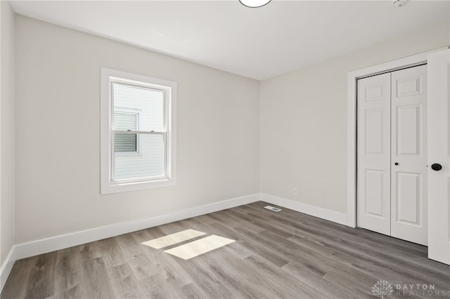 235 N Delmar Ave, Dayton, OH 45403 - unfurnished bedroom with wood finished floors, baseboards, and a closet