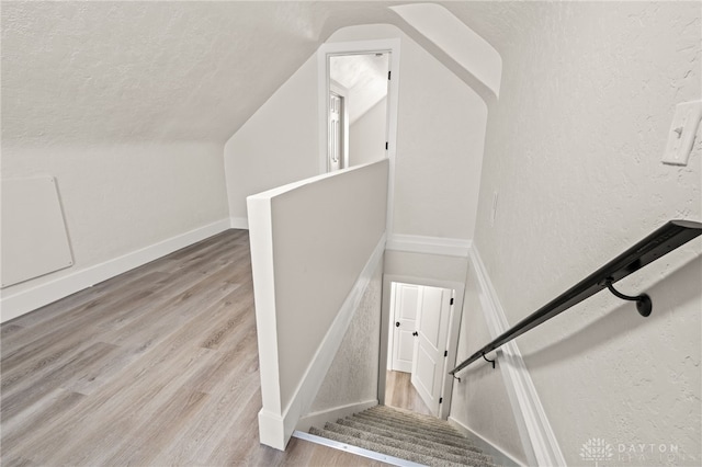 235 N Delmar Ave, Dayton, OH 45403 - staircase with lofted ceiling, wood finished floors, a textured ceiling, a textured wall, and baseboards