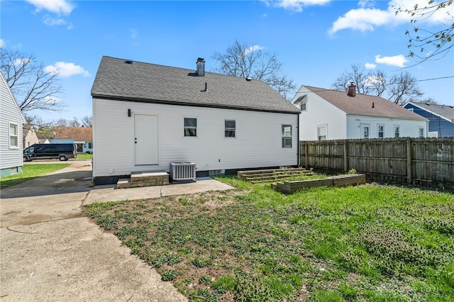 235 N Delmar Ave, Dayton, OH 45403 - rear view of house with central air condition unit, a garden, a chimney, and a shingled roof