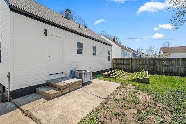 235 N Delmar Ave, Dayton, OH 45403 - back of house with central AC unit, a garden, fence, and a shingled roof