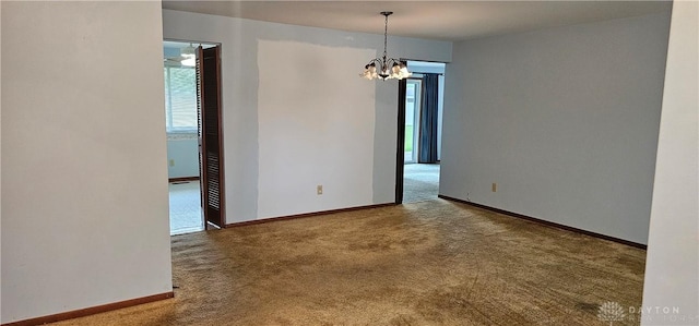unfurnished room with carpet flooring, healthy amount of natural light, a chandelier, and baseboards