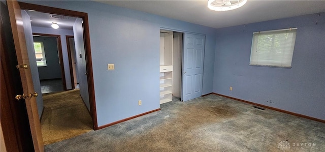 unfurnished bedroom featuring carpet flooring, baseboards, and a closet