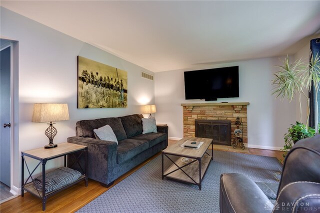 8188 Inwood Ave, Dayton, OH 45415 - living area with wood finished floors, a stone fireplace, and baseboards