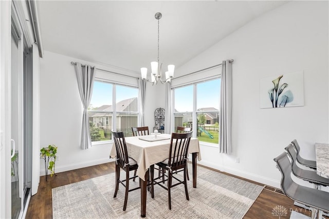 dining area featuring lofted ceiling, a chandelier, healthy amount of natural light, baseboards, and dark wood-style flooring