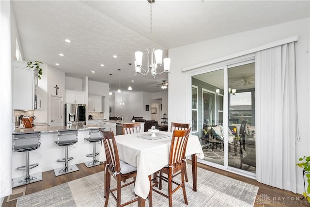 dining room featuring dark wood-style floors, ceiling fan, a chandelier, and recessed lighting