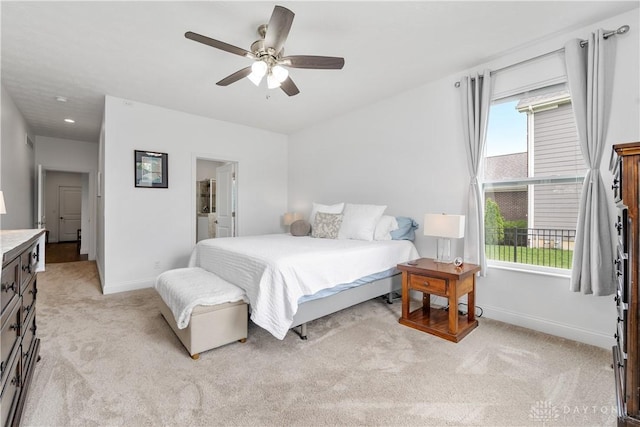 bedroom with light carpet, baseboards, a ceiling fan, and connected bathroom