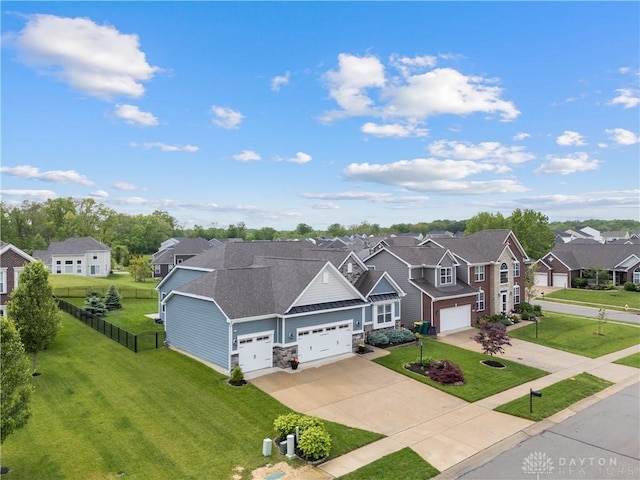 view of front facade with a residential view, driveway, stone siding, and an attached garage