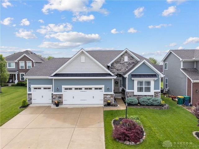 craftsman-style home featuring stone siding, an attached garage, concrete driveway, a front lawn, and a standing seam roof