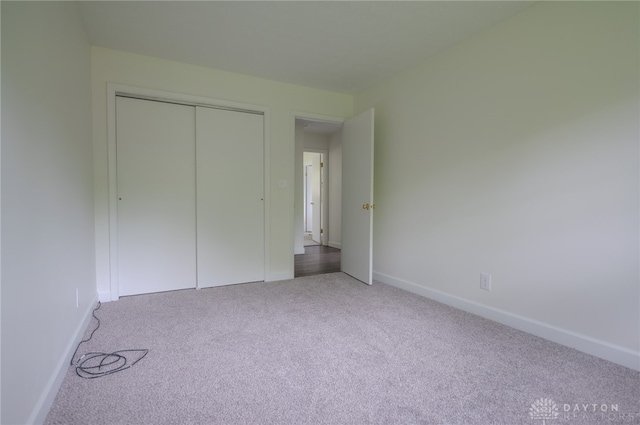 unfurnished bedroom featuring carpet flooring, baseboards, and a closet