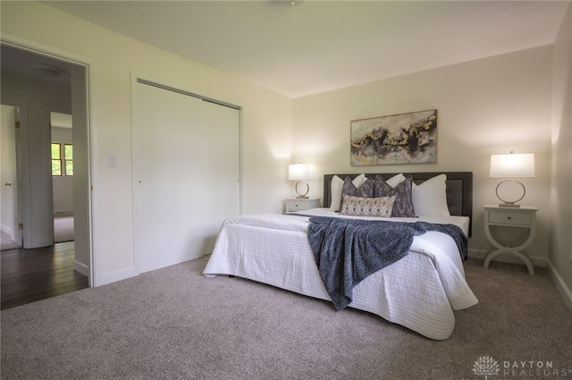 carpeted bedroom with a closet and baseboards