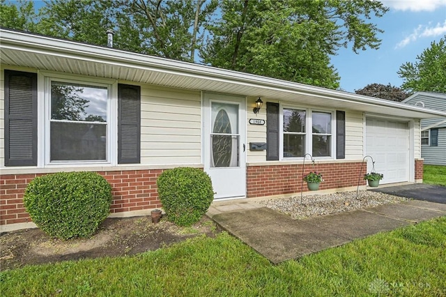 view of front of house with brick siding, an attached garage, and driveway