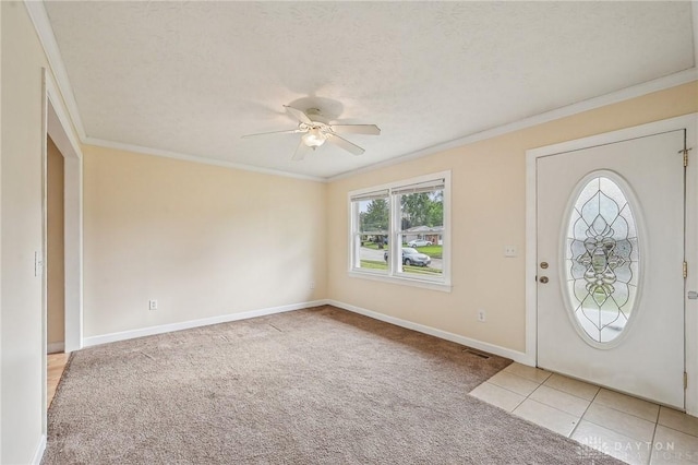 entrance foyer featuring light colored carpet, ornamental molding, ceiling fan, and baseboards