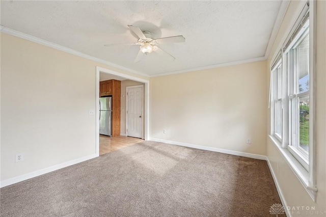 unfurnished room featuring light carpet, baseboards, a ceiling fan, and ornamental molding