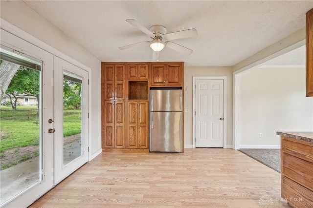 kitchen with freestanding refrigerator, brown cabinetry, light wood finished floors, and ceiling fan