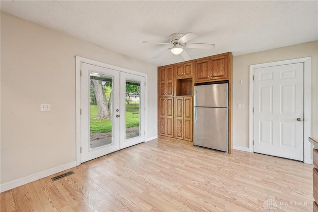 kitchen with freestanding refrigerator, french doors, a ceiling fan, baseboards, and light wood-type flooring