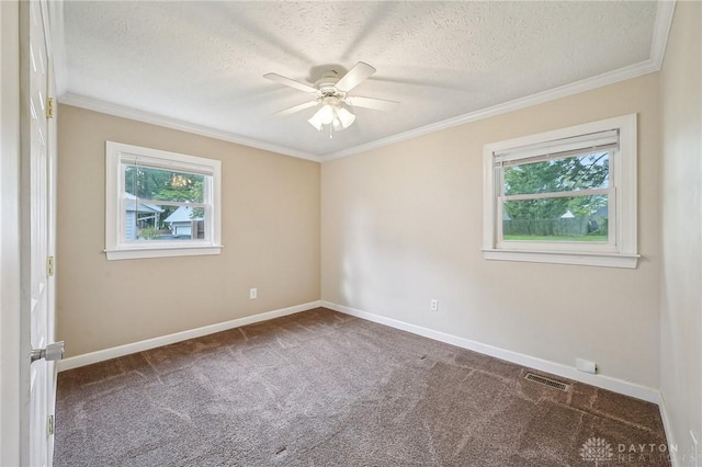 carpeted spare room with ceiling fan, baseboards, a textured ceiling, and crown molding