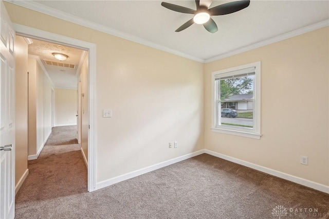 empty room with carpet, ceiling fan, baseboards, and ornamental molding
