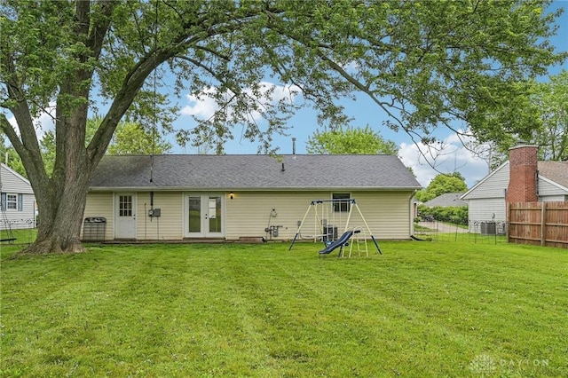 rear view of property featuring french doors, a playground, and central air condition unit