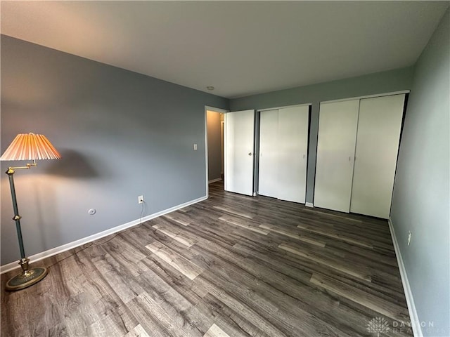5700 Coach Dr Unit B, Kettering, OH 45440 - unfurnished bedroom featuring two closets, wood finished floors, and baseboards