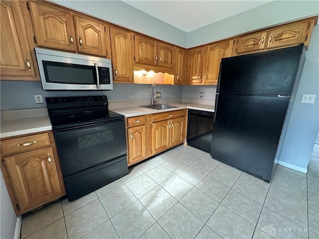 5700 Coach Dr Unit B, Kettering, OH 45440 - kitchen with black appliances, a sink, light countertops, light tile patterned floors, and brown cabinets