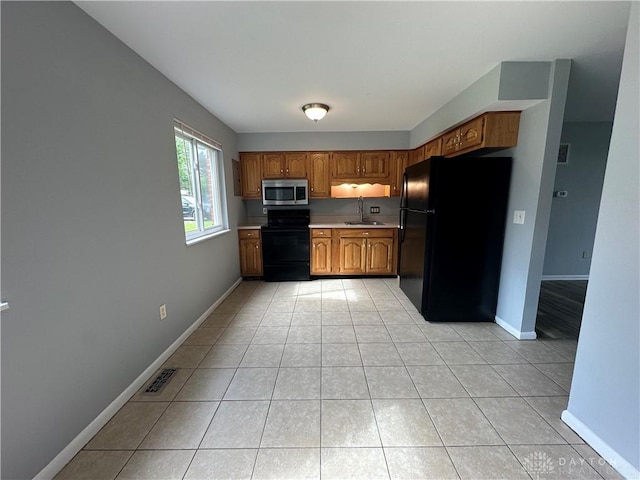 5700 Coach Dr Unit B, Kettering, OH 45440 - kitchen with black appliances, a sink, light countertops, brown cabinetry, and light tile patterned flooring