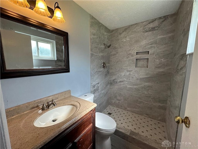 5700 Coach Dr Unit B, Kettering, OH 45440 - full bathroom with a tile shower, toilet, vanity, and a textured ceiling