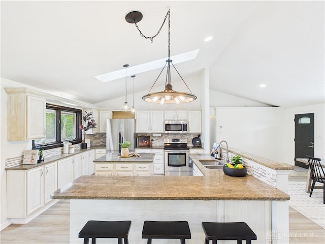 9094 Mary Haynes Dr, Washington Twp, OH 45458 - kitchen with appliances with stainless steel finishes, a skylight, a large island with sink, a sink, and a kitchen breakfast bar