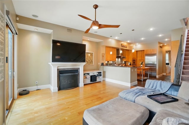 2731 Cleinview Ave Unit 2, Cincinnati, OH 45206 - living room with a fireplace, a ceiling fan, light wood-style flooring, stairs, and baseboards