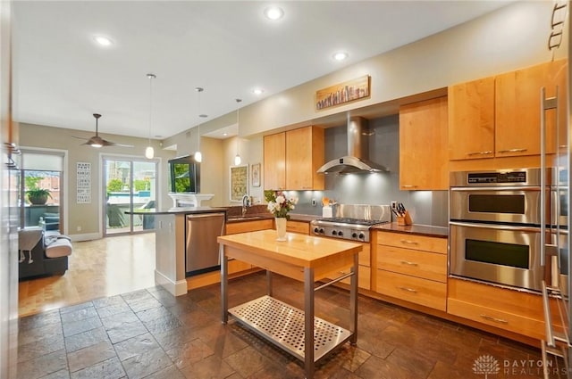 2731 Cleinview Ave Unit 2, Cincinnati, OH 45206 - kitchen featuring wall chimney exhaust hood, appliances with stainless steel finishes, a peninsula, a sink, and stone tile floors