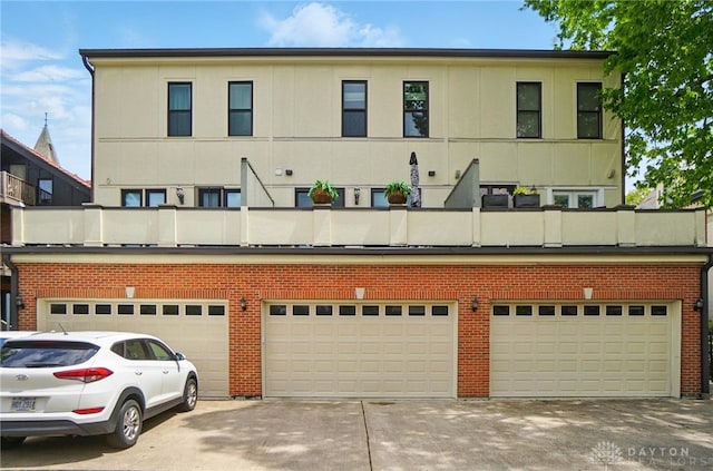 2731 Cleinview Ave Unit 2, Cincinnati, OH 45206 - rear view of property featuring concrete driveway, a balcony, and brick siding