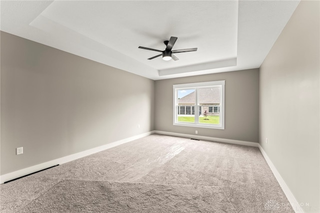755 W Bentley Cir, Troy, OH 45373 - spare room featuring a raised ceiling, carpet, a ceiling fan, and baseboards