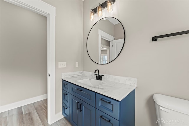 755 W Bentley Cir, Troy, OH 45373 - bathroom featuring wood finished floors, vanity, toilet, and baseboards