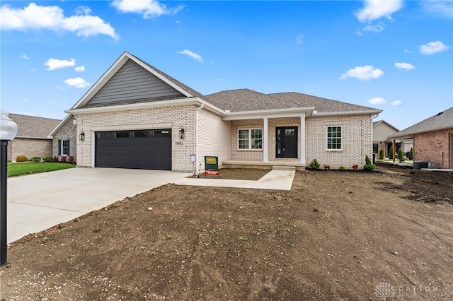 755 W Bentley Cir, Troy, OH 45373 - view of front of house with brick siding, an attached garage, concrete driveway, cooling unit, and a porch