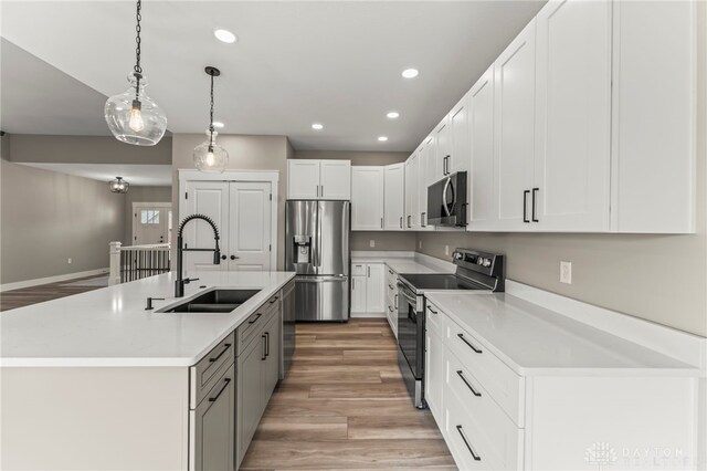 755 W Bentley Cir, Troy, OH 45373 - kitchen featuring appliances with stainless steel finishes, a sink, light wood-style flooring, recessed lighting, and decorative light fixtures