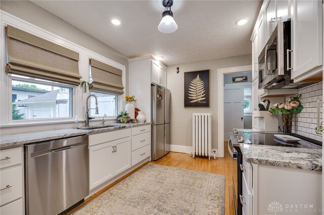 65 N Central Ave, Fairborn, OH 45324 - kitchen featuring appliances with stainless steel finishes, light wood-style floors, decorative backsplash, white cabinetry, and recessed lighting
